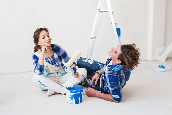 Renovation, redecoration and people concept - young couple doing a renovation in new home — Stock Photo, Image