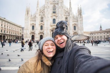 Milano Duomo Meydanı'nda güvercin ile kendi kendine portre çekici çift. Kış seyahat, İtalya ve ilişki kavramı
