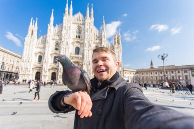 Seyahat, tatil ve kış tatil kavramı - mutlu adamı kabul selfie fotoğraf komik güvercinler ile Duomo Milan Katedrali önünde