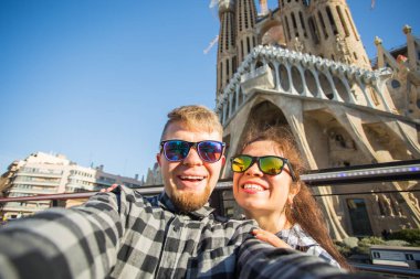 Barcelona, İspanya - 7 Şubat 2018: mutlu çift selfie fotoğraf ünlü Sagrada Familia Katolik Katedrali önünde yapma. Barselona bölgesindeki seyahat