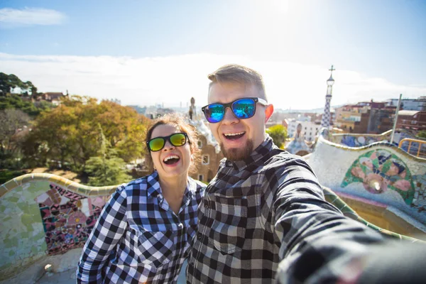 Pareja de viajes feliz haciendo retrato selfie con smartphone en Park Güell, Barcelona, España . — Foto de Stock