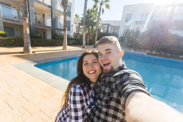 Reise, Menschen und Urlaubskonzept - glückliches Paar beim Selfie am Pool — Stockfoto
