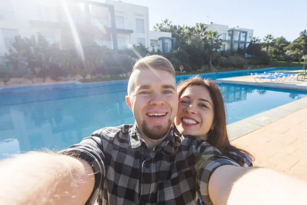 旅行、休暇や休日のコンセプト - 美しい愛のカップルが楽しんでスイミング プールの近くの selfie の撮影 — ストック写真