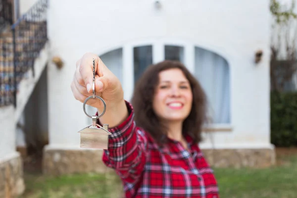 Propiedad, bienes raíces, concepto de compra y alquiler - Mujer con llaves de pie fuera de casa nueva —  Fotos de Stock