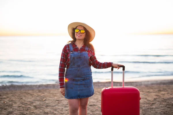 Férias, viagens e turismo conceito - Mulher bonita com mala vermelha sobre fundo de praia arenosa — Fotografia de Stock