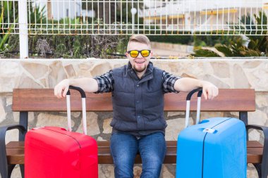 Seyahat, insanlar ve tatil kavramı - iki bavul ile oturan genç adam. Gezi hazır