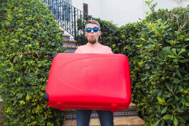 Tatil, gezi ve tatil kavramı - kırmızı seyahat bavul seyahat etmeye hazır olan adam