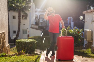 Tatil, seyahat ve boşluk kavramı - genç adam açık havada bavulla ayakta