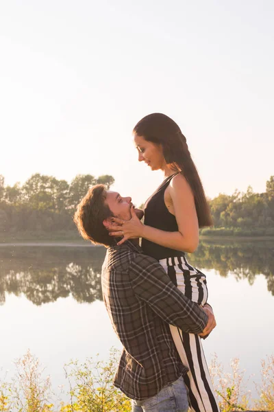 Gente, amor y concepto de la naturaleza - Hombre sosteniendo a la mujer en sus brazos sobre el fondo de la naturaleza —  Fotos de Stock