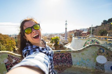 Seyahat ve tatil kavramı - mutlu kadın selfie portre ile smartphone Park Guell, Barselona, İspanya, yapma.