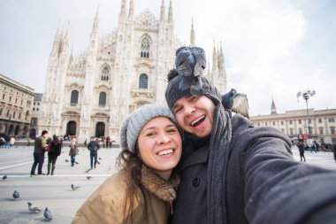 Milano Duomo Meydanı'nda güvercin ile kendi kendine portre çekici çift. Kış seyahat, İtalya ve ilişki kavramı