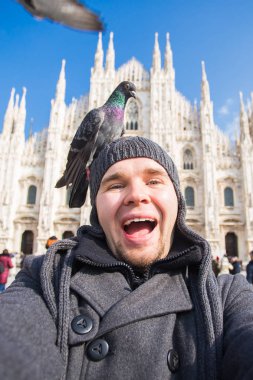 Seyahat, tatil ve kış tatil kavramı - mutlu adamı kabul selfie fotoğraf komik güvercinler ile Duomo Milan Katedrali önünde