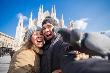 Milano Duomo Meydanı'nda güvercin ile kendi kendine portre çekici çift. Kış seyahat, İtalya ve ilişki kavramı
