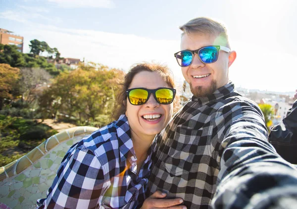 Funny young couple looking at camera taking photo with smart phone smiling in Park Guell, Barcelona, Spain. — Stock Photo, Image