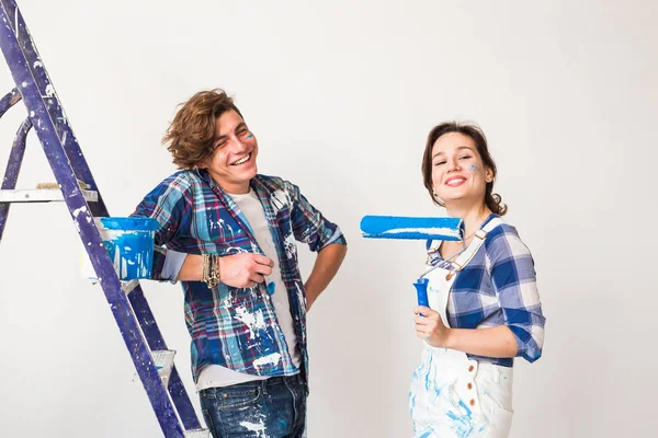 Rénovation, réparation et concept de personnes - Jeunes mariés peignant des murs dans leur nouvelle maison . — Photo