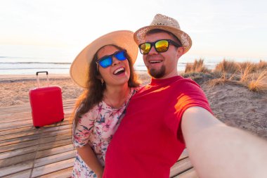 Gezi, tatil ve tatil kavramı - genç ve güzel kadın ve hasır şapkalar yakışıklı erkek arkadaşını selfie olun