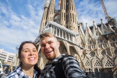 Barcelona, İspanya - 6 Şubat 2018: mutlu çift selfie fotoğraf ünlü Sagrada Familia Katolik Katedrali önünde yapma. Barselona bölgesindeki seyahat