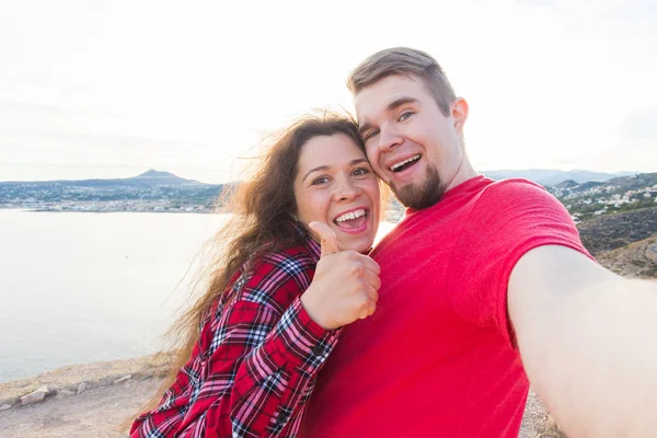 Conceito de viagem, férias e férias - Belo casal se divertindo, tirando selfie, rostos emocionais loucos e rindo . — Fotografia de Stock