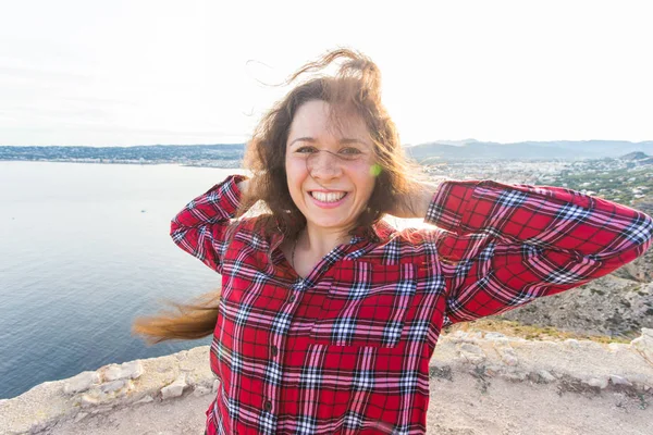 Geluk, emoties en reizen concept - lachen sproeten vrouw met krullend haar buitenshuis — Stockfoto