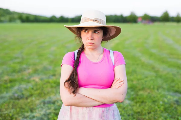 Finster gelangweiltes Mädchen runzelt die Stirn und schaut zur Seite. Wütende Frau steht draußen und wartet auf Antworten. — Stockfoto