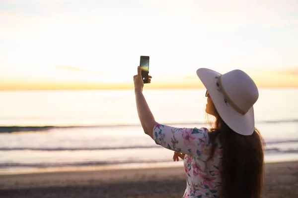 Gezgin genç kadın cep telefonu kamera güzel günbatımı manzara video çekiyor. Yaz tatil seyahat ve tatil. — Stok fotoğraf