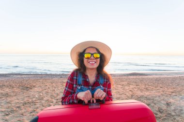 Gezi, tatil ve tatil kavramı - bavul sahilde tutan komik genç kadın