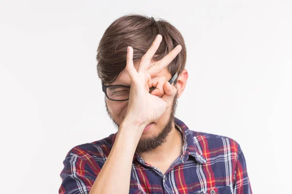 Joven hombre creativo sosteniendo los dedos cerca de los ojos como gafas. Concepto divertido , — Foto de Stock