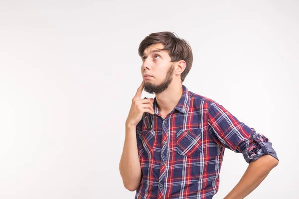 Emoções e conceito de pessoas - jovem homem pensativo no fundo branco com espaço de cópia — Fotografia de Stock