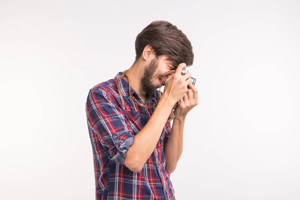 Tecnologia, fotografia e conceito de pessoas - Bonito homem de camisa xadrez tirar uma foto na câmera retro — Fotografia de Stock