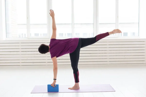 Personas, yoga, deporte y concepto de salud - Mujer de mediana edad practicando yoga, utilizando cubo de estiramiento —  Fotos de Stock