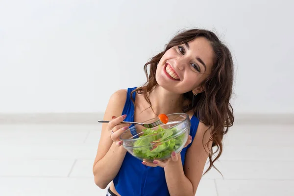 Comida, estilo de vida saudável, conceito de pessoas - Mulher jovem comendo salada e sorrindo — Fotografia de Stock
