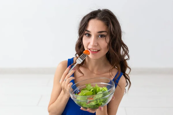 Comida, estilo de vida saudável, conceito de pessoas - Mulher jovem comendo salada e sorrindo — Fotografia de Stock