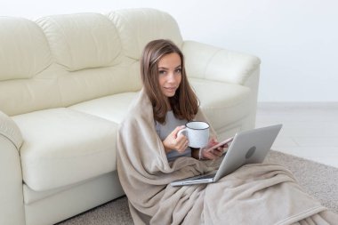 Çalışma, rahat, insanlar kavramı - ekose evde çalışma, çay içme ve netbook chat yapan genç kadın