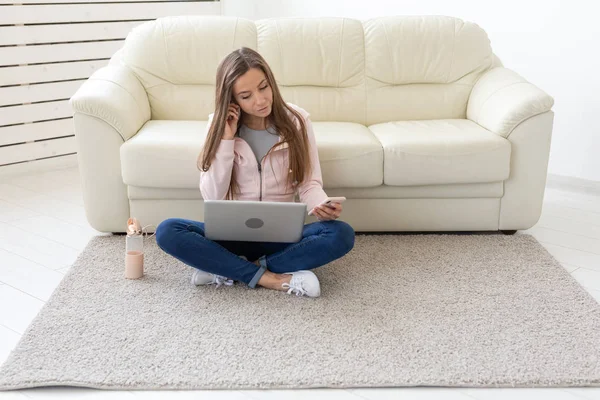 Koncepcja freelance i ludzie - młoda kobieta siedzi na podłodze i pracę na laptopie — Zdjęcie stockowe