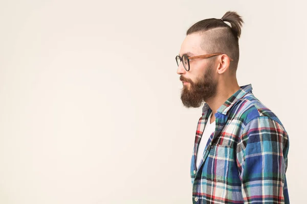 Hipster, mode, concept de personnes - jeune homme barbu hipster en lunettes et chemise debout sur le fond blanc avec espace de copie, vue latérale — Photo