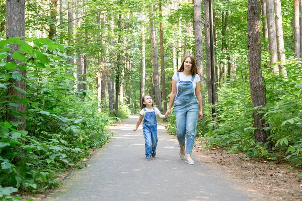 Családi, természet és ember fogalom - anya és lánya időt együtt a zöld parkban sétálni — Stock Fotó