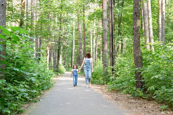 Familie-, zomer- en natuur concept - moeder en dochter lopen in de verte — Stockfoto