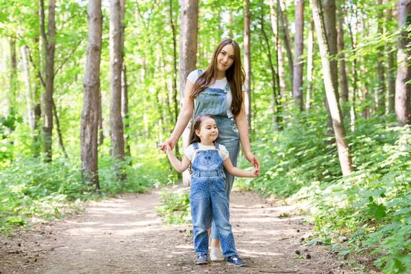 Familien-, Natur- und Menschenkonzept - Mutter und süße kleine Tochter verbringen Zeit miteinander beim Waldspaziergang — Stockfoto