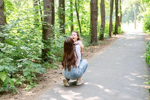 Οικογένεια και φύση έννοια - ελκυστική νεαρή γυναίκα να διασκεδάσουν με τη μικρή της κόρη στο πάρκο — Φωτογραφία Αρχείου