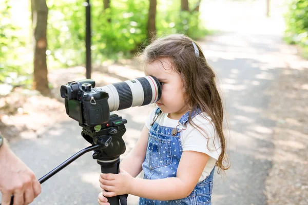 Hobby, povolání, děti a fotograf koncept - dítě s kamerou v lese — Stock fotografie