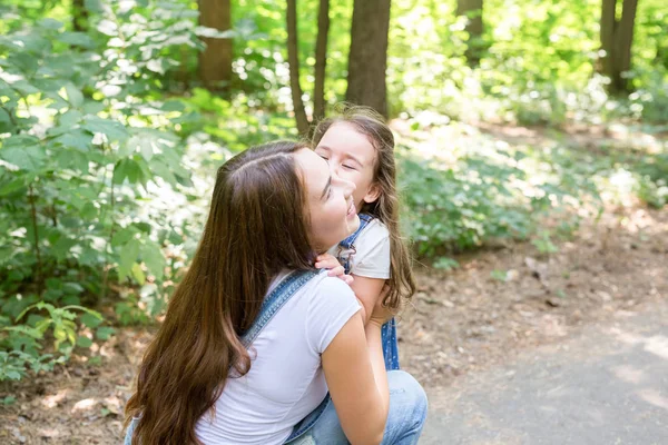 Familien-, Natur- und Menschenkonzept - Mutter und süße kleine Tochter kuscheln im Sommerpark — Stockfoto