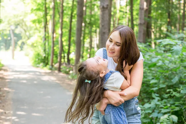 Концепция семьи и природы - Портрет матери с ребенком, играющей в зеленом парке — стоковое фото