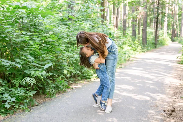 Famiglia, natura, concetto di persone - madre e figlia che si abbracciano nel parco — Foto Stock