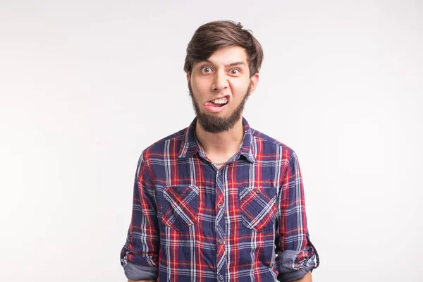 Expression, april fools day and joke concept - Young funny bearded man sticks his tongue out — Stok Foto