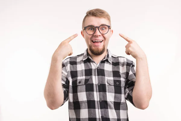 Lustiger Mann im karierten Hemd deutet auf sein lächelndes Gesicht vor weißem Hintergrund — Stockfoto