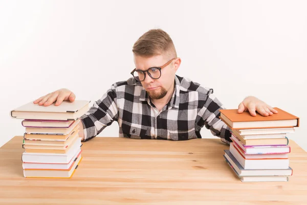 Persone, conoscenza e concetto di istruzione - Studente maschio stanco seduto a tavola con montagne di libri e non vuole studiare fino — Foto Stock