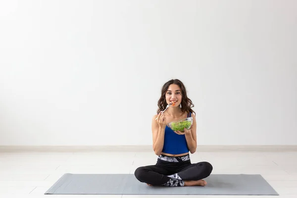 Mode de vie sain, personnes et concept sportif - Femme de yoga avec un bol de salade de légumes — Photo