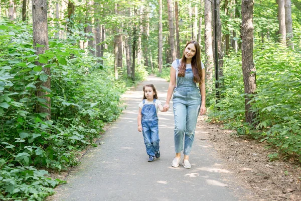 Családi, természet, gyerekek koncepció - anya és lánya kis időt együtt egy séta a parkban a nyáron — Stock Fotó