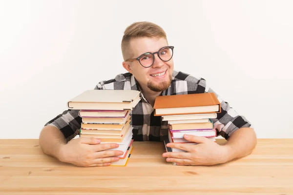 Persone, conoscenza ed educazione - studente sorridente seduto a tavola con i libri. Gli piace leggere e studiare. . — Foto Stock