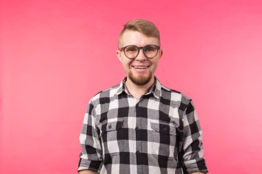 Gözlük kamera pembe arka plan üzerinde izole bakarak erkekte bir gülümseyen portresi sakallı